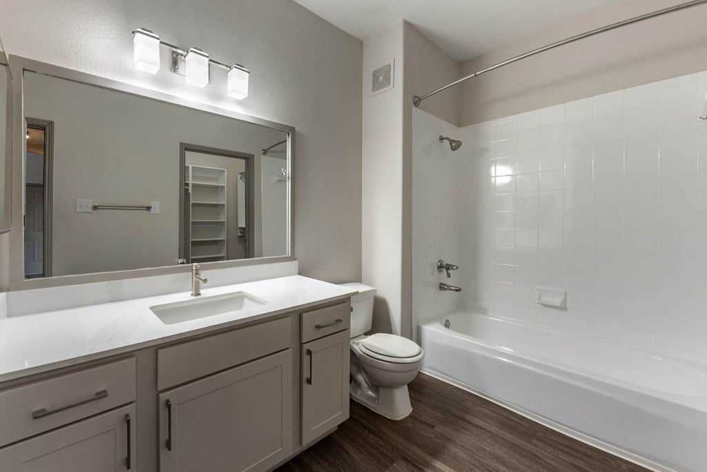 a bathroom with a toilet sink and shower and a mirror